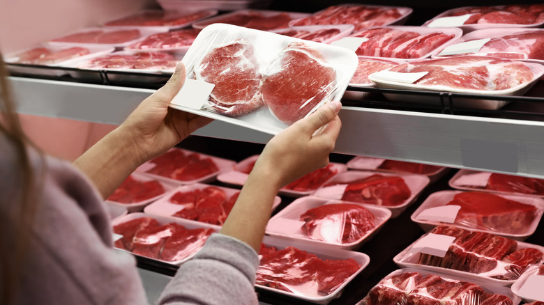 Woman holding package of meat