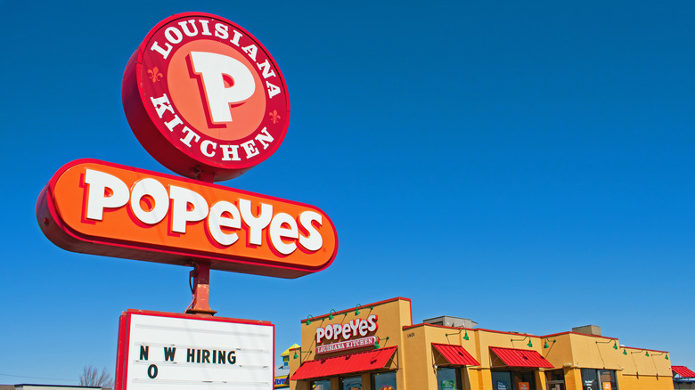 Popeyes sign with 'now hiring' marqee