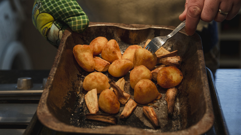 Flipping roasted potatoes in a sheet pan