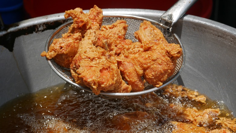 deep frying chicken with strainer