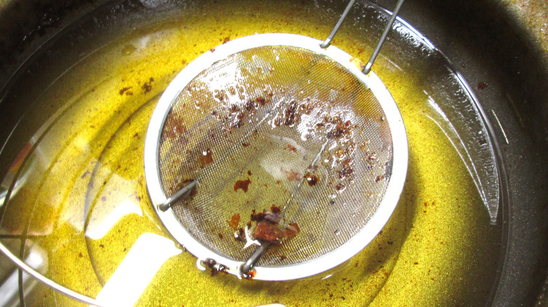 straining frying oil with fried bits