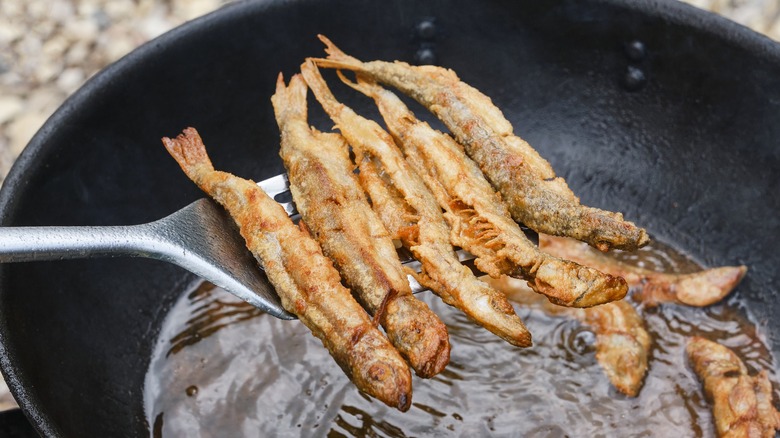 fried fish being scooped out