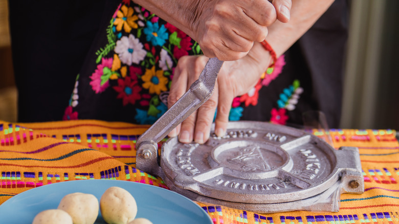 hands using tortilla press