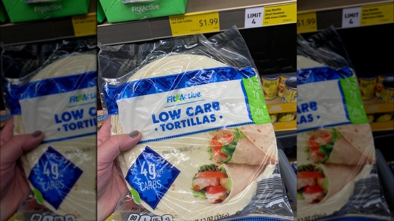 Person holding up tortillas next to Aldi price tag