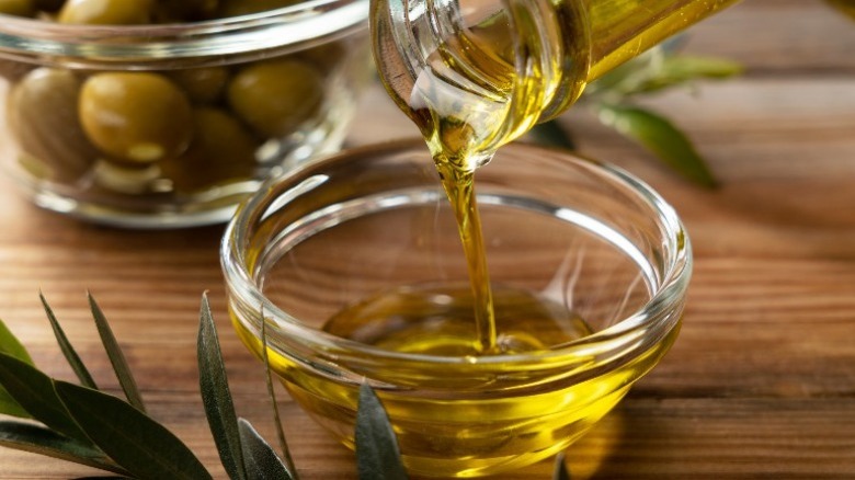 Oil being poured into a small glass bowl