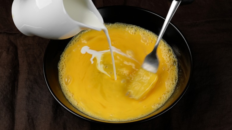 stirring cream into scrambled egg pan