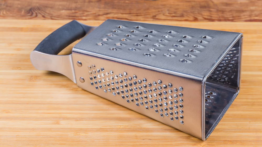 Grater on wooden cutting board