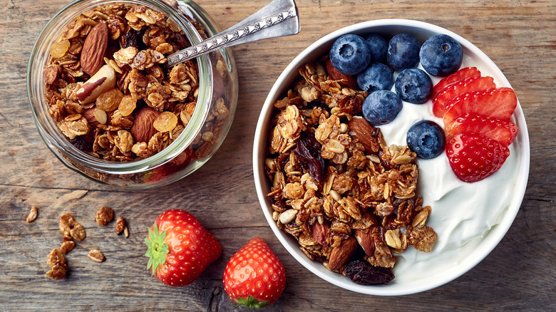 jar of granola and bowl of yogurt with fruit and granola