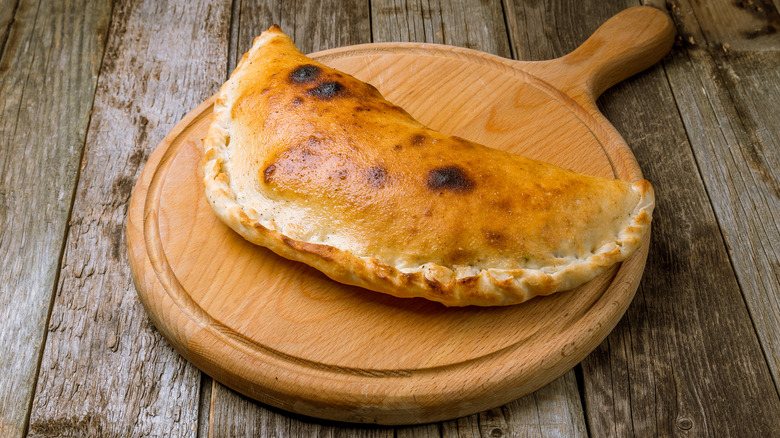 calzone on wooden cutting board