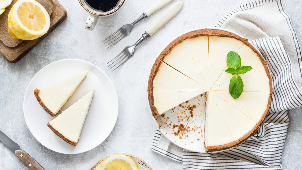 whole cheesecake on counter with two slices on plate