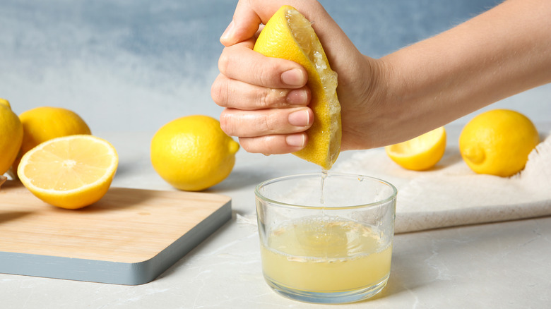 Person squeezing half a lemon