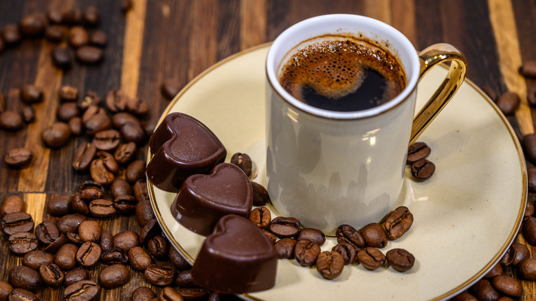 Chocolate hearts next to mug of espresso and beans