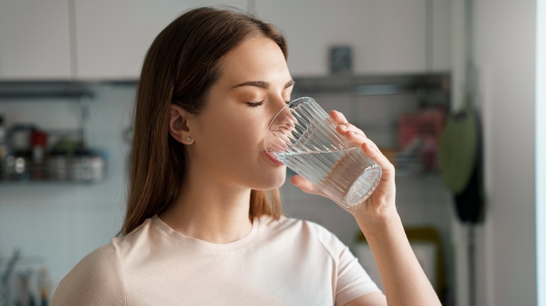 woman drinking water from glass