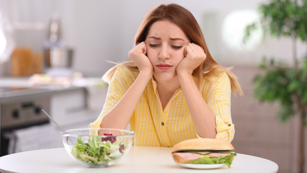 sad woman looking at sandwich