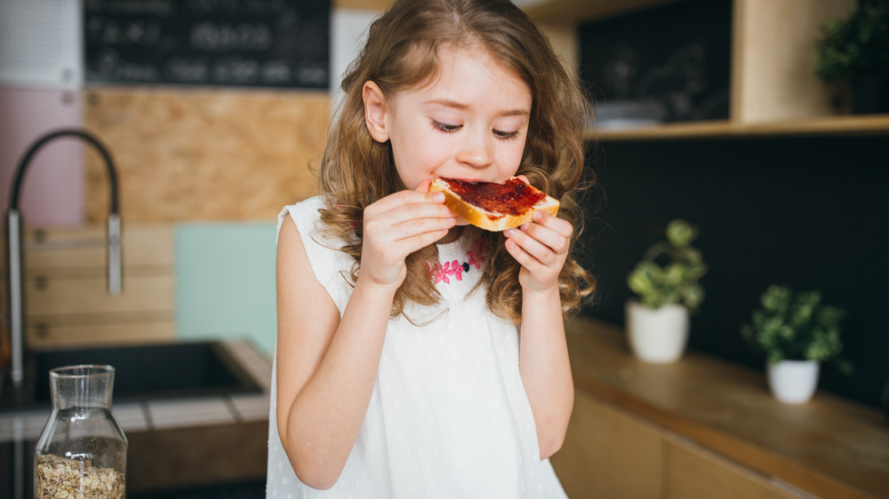 little girl eating white bread