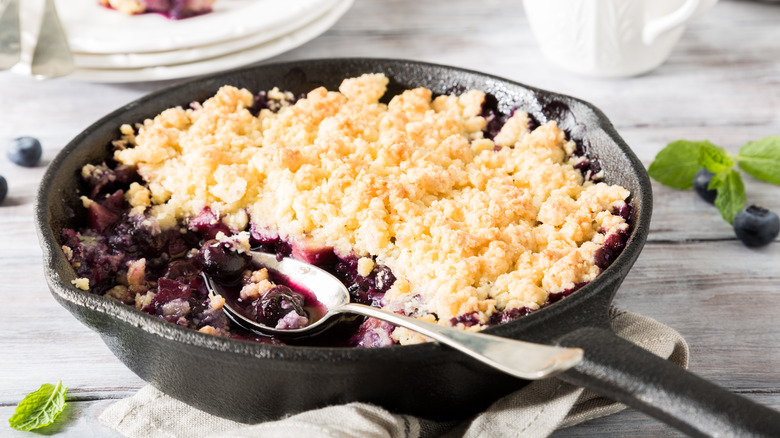 cast iron pan full of fruit cobbler