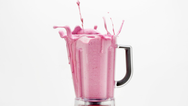 pink smoothie splashing in blender 
