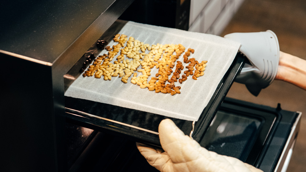 Taking roasted nuts out of the oven