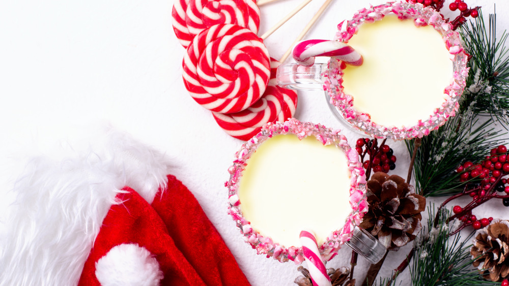 Mugs of Eggnog with peppermint, evergreen branches, and Santa hats