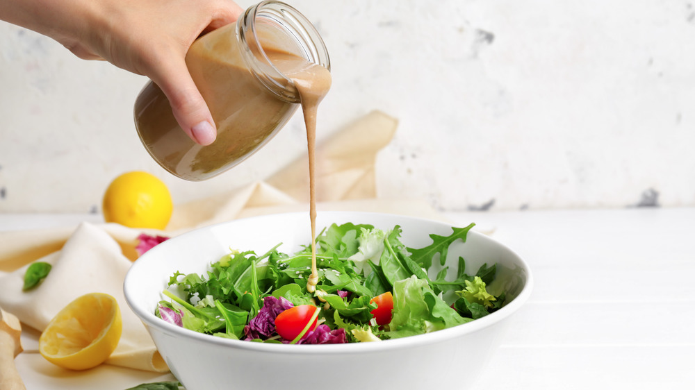 Person pouring homemade dressing