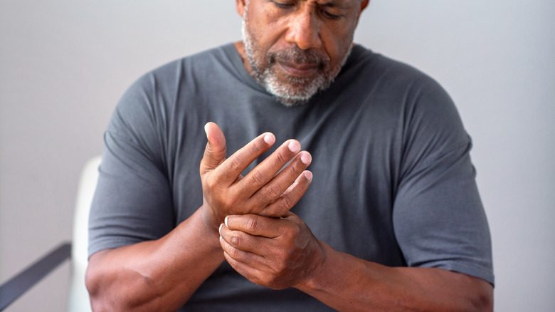 Man rubbing arthritic hand