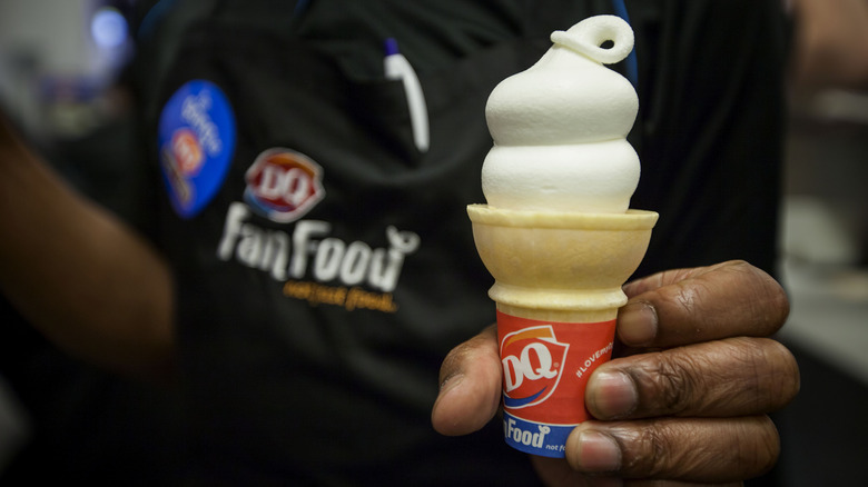 Worker holding Dairy Queen vanilla cone