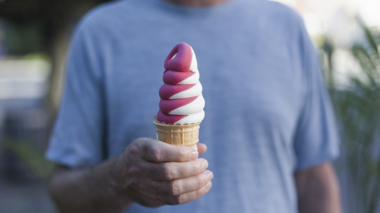 Man holding pink and white soft serve ice cream