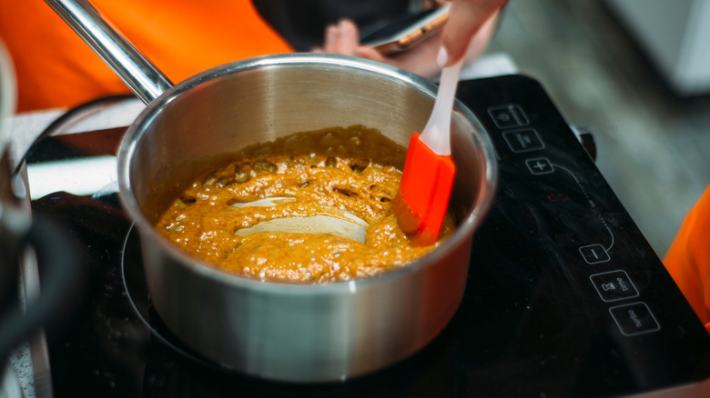 Person making caramel sauce in silver pan