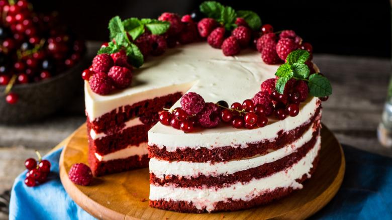 Red velvet cake decorated with frosting and berries