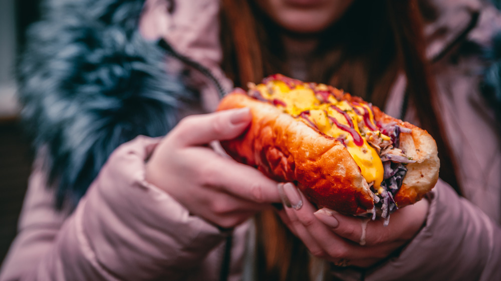 Woman holding a Philly Cheesesteak sandwich from a street vendor