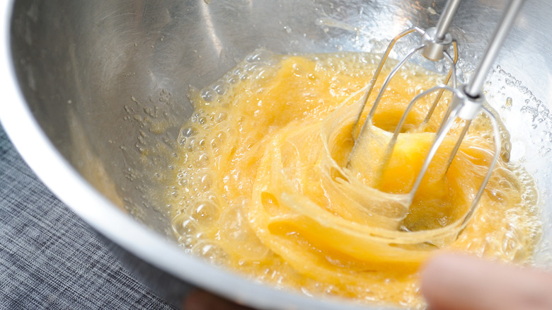 Eggs being whipped in a stainless steel bowl