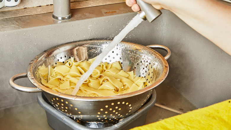 Pasta being rinsed in a sink