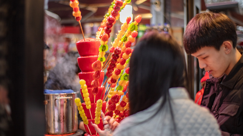 buying tanghulu from street vendor