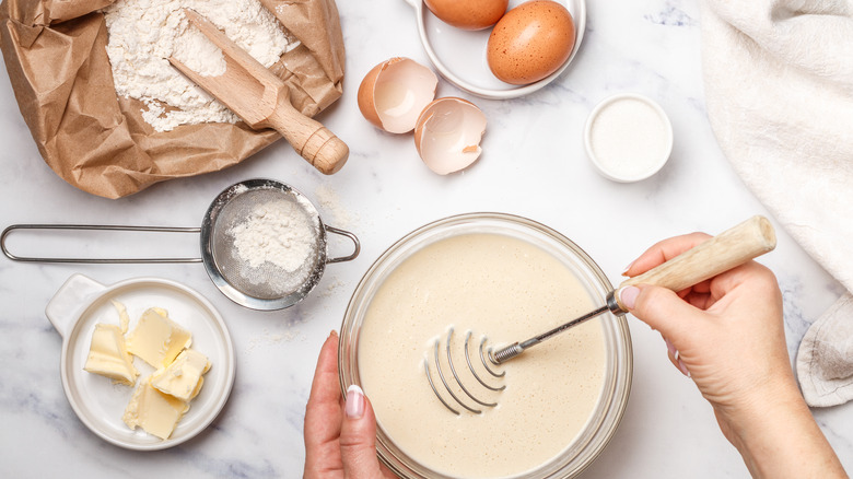 hands mixing batter with cake ingredients