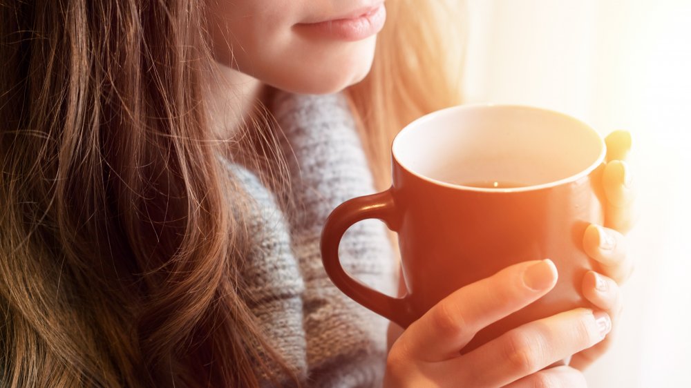 Woman holding a cup of tea to relax