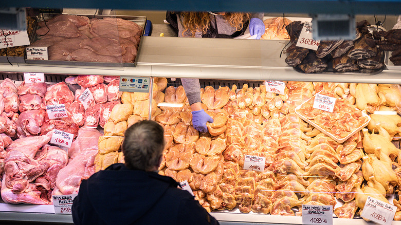Man buying chicken at a meat counter