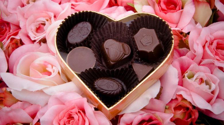 Heart shaped chocolate box on bed of roses