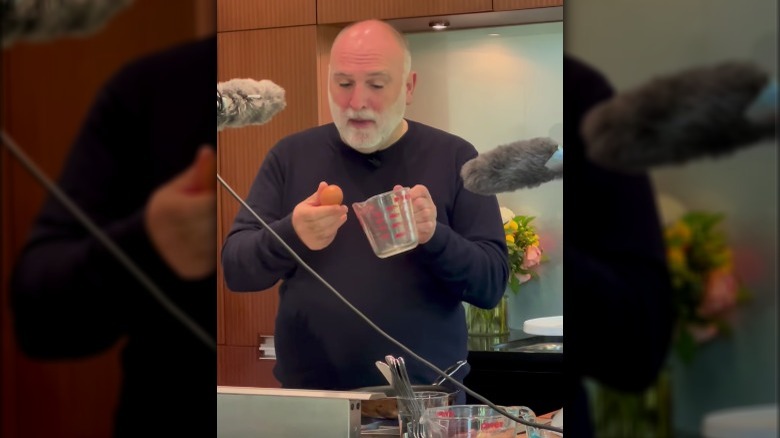 Chef José Andrés holding an egg and a pyrex cup