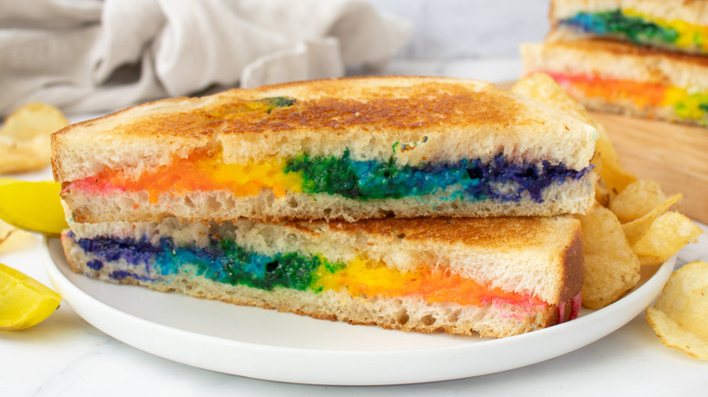 colorful rainbow grilled cheese halves stacked on plate