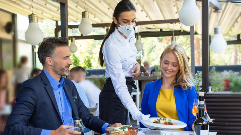 server and diners at a restaurant