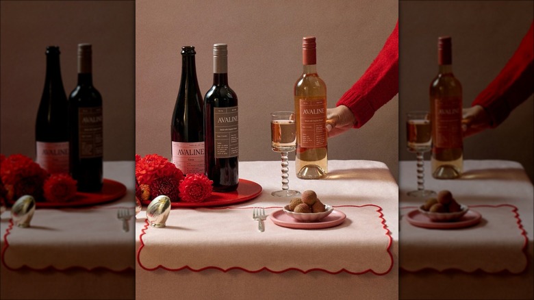 Hand holding wine bottle on decorated table