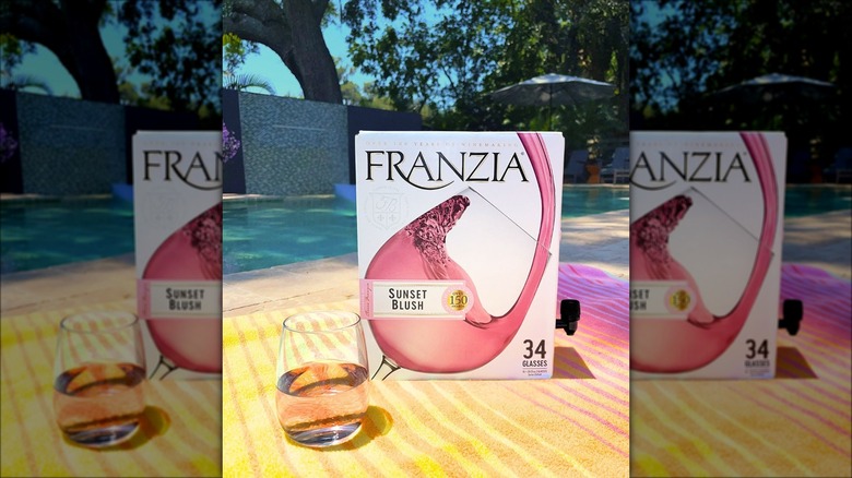 Box of rosé on beach towel with glass