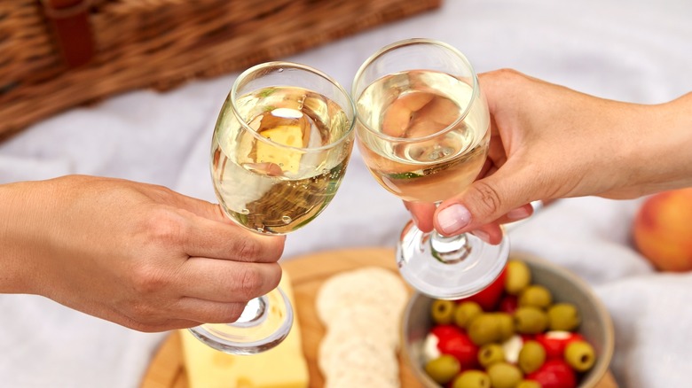 couple toasting with moscato wine over a charcuterie board