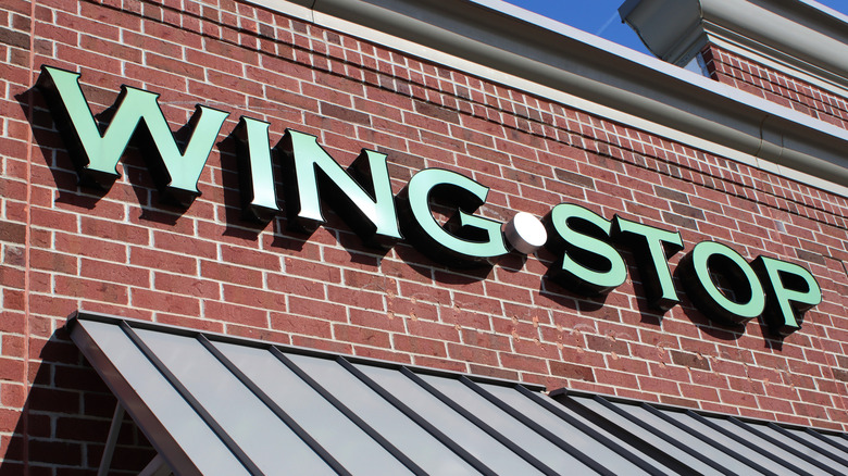 Wing stop signage against red brick