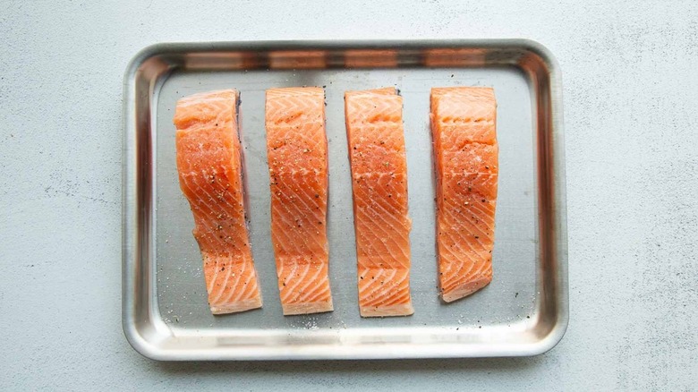 raw salmon fillets on sheet pan