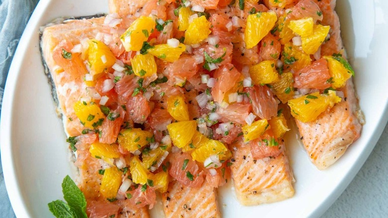 baked salmon with citrus salsa on white platter