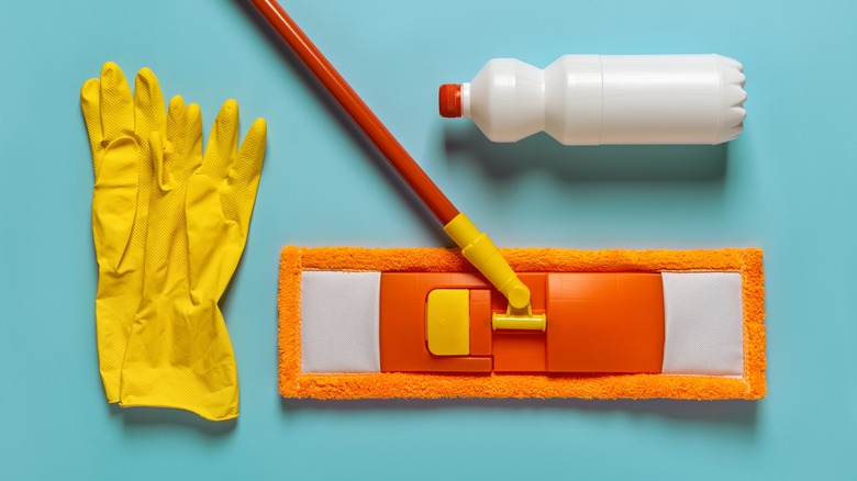 Mop and cleaning supplies on blue background