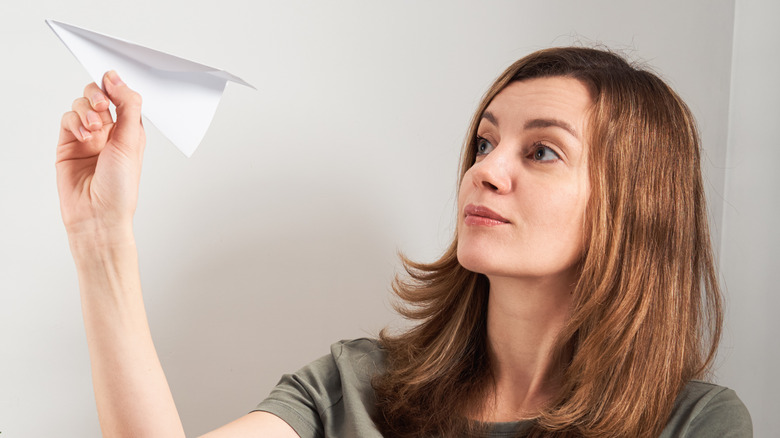 woman throwing paper airplane