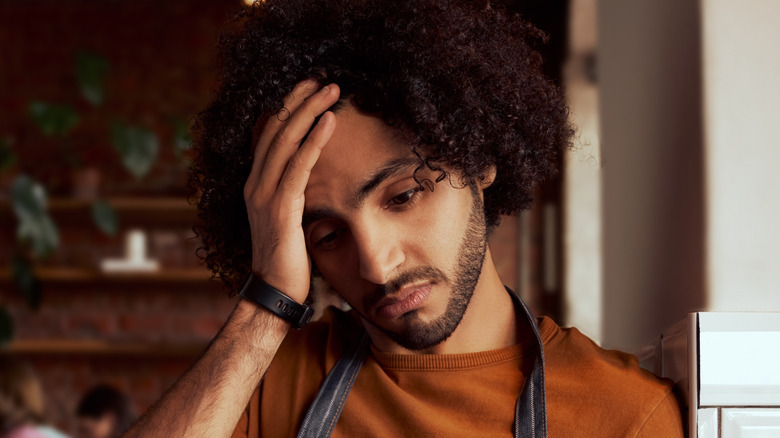 frustrated waiter holding head