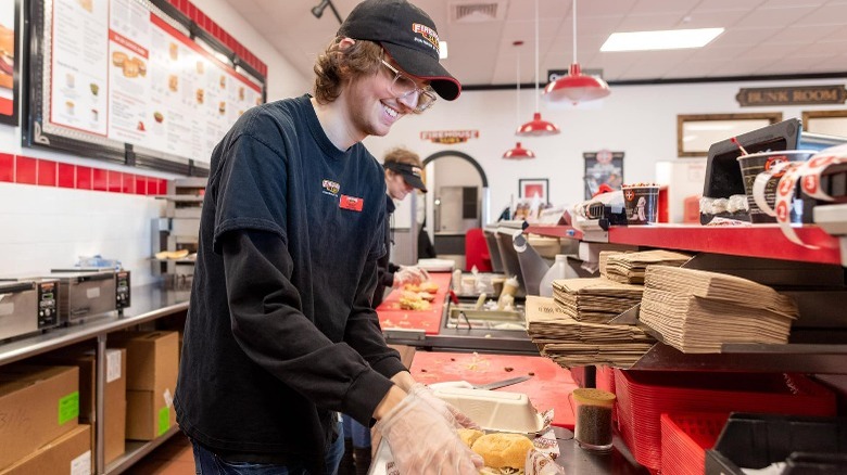 An employee preparing a sandwich at Firehouse Subs.